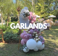 a balloon stand with a sign that says garlands