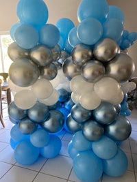 a group of blue and silver balloons in a room